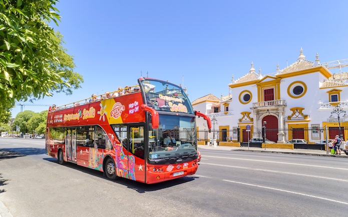 Open-top tour bus in front of Plaza de Toros, Seville.