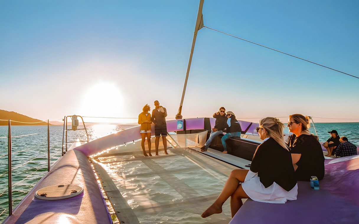 Sailing group enjoying sunset on Camira catamaran, Airlie Beach.
