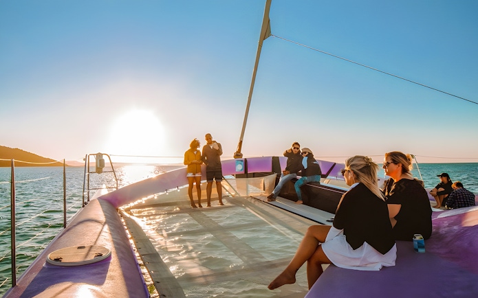 Sailing group enjoying sunset on Camira catamaran, Airlie Beach.