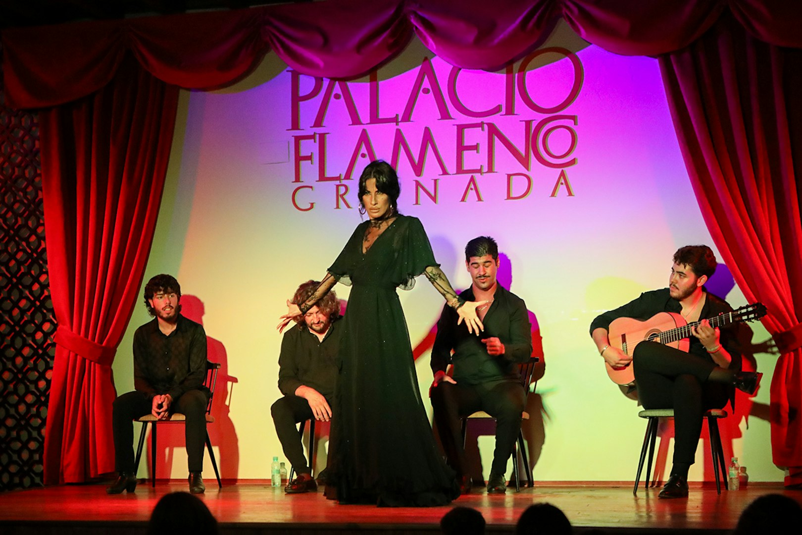 Flamenco dancer performing at Palacio de los Olvidados in Granada with musicians.