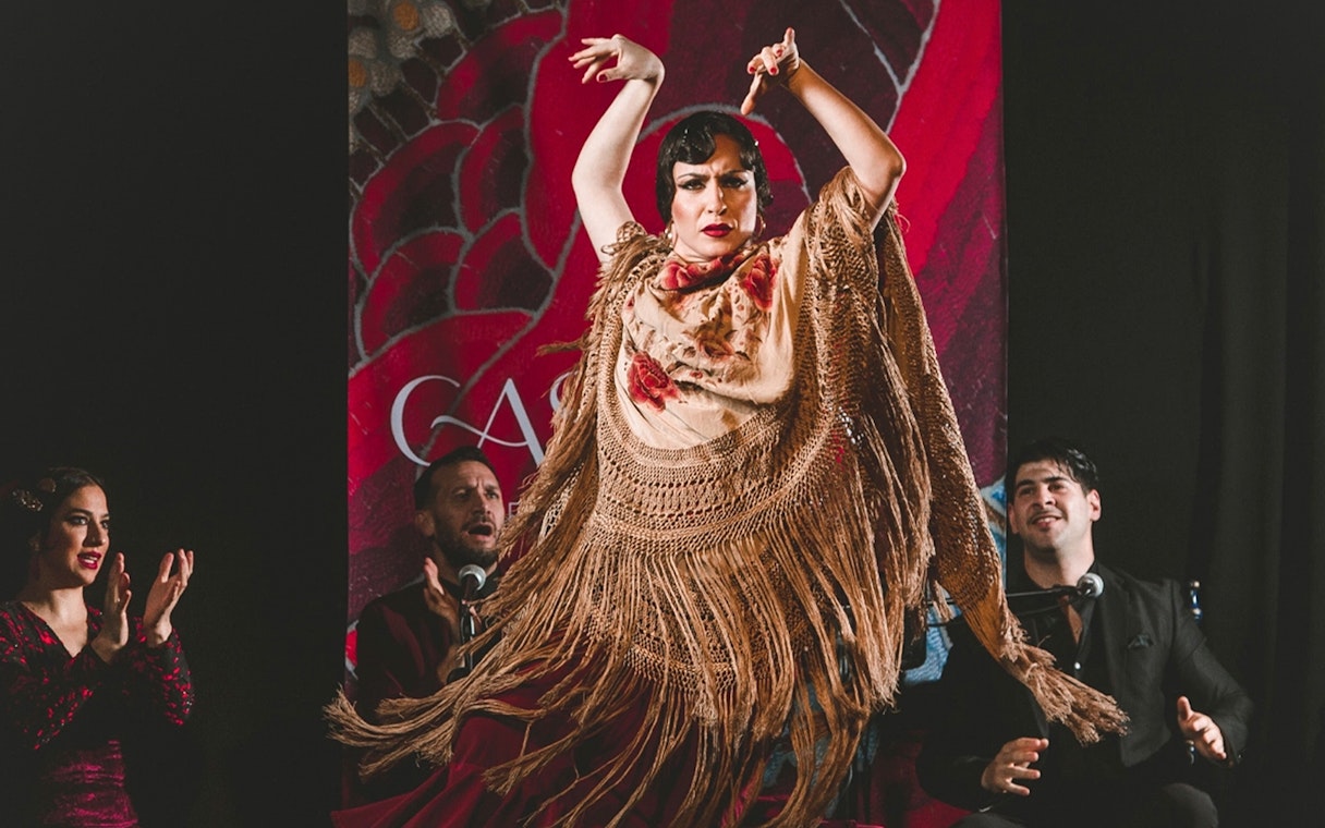 Flamenco dancer performing at Casa Ana with musicians in the background.