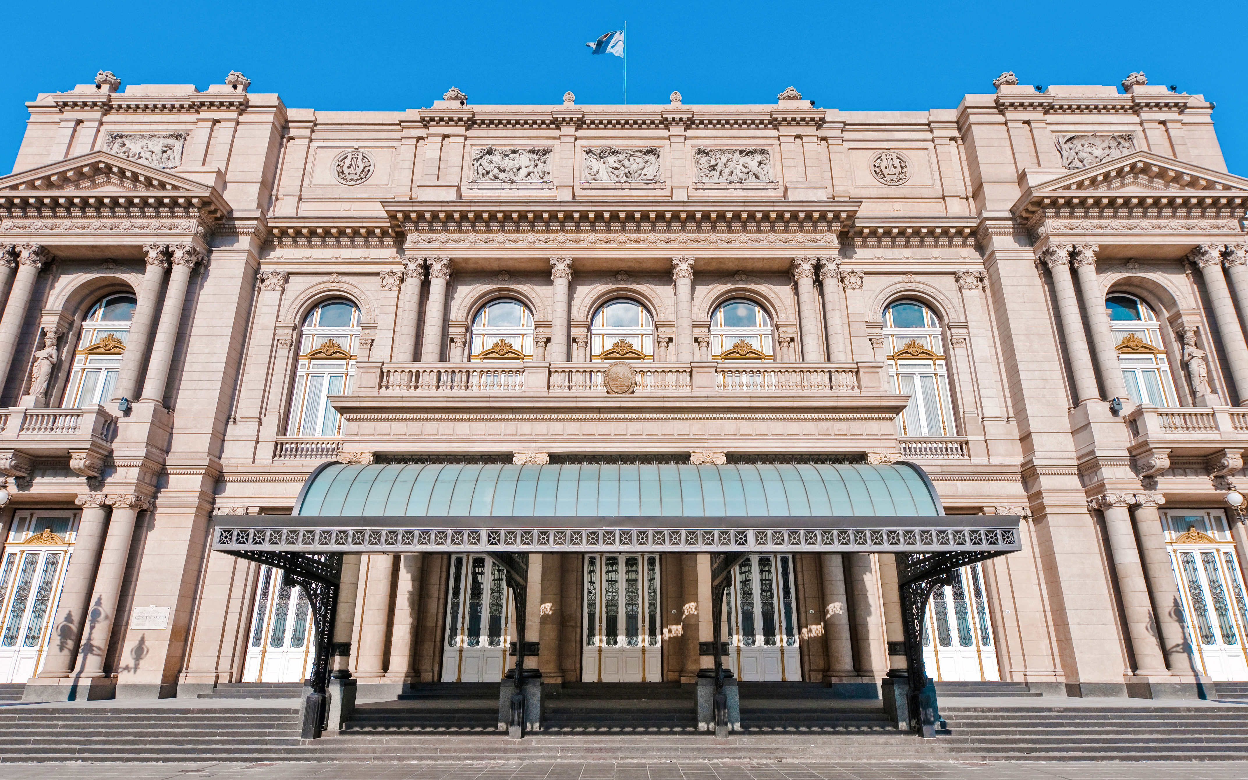 Colon Theatre facade on 9 de Julio Avenue, Buenos Aires, showcasing neoclassical architecture.