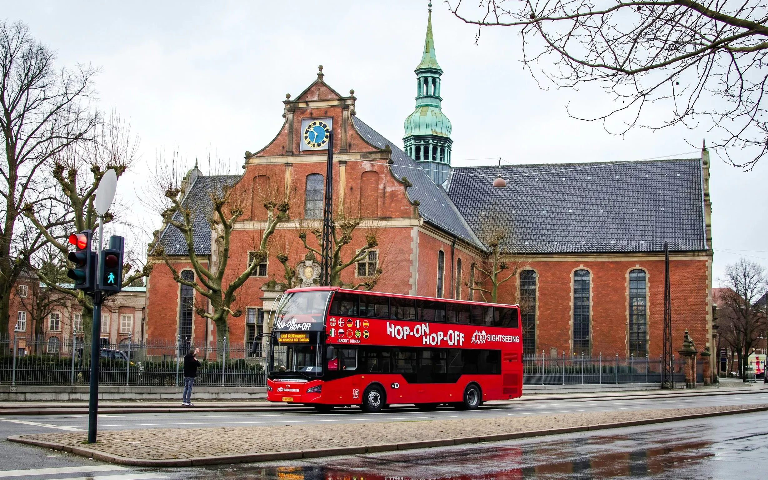 Red Sightseeing's Copenhagen hop-on hop-off bus near historic church.