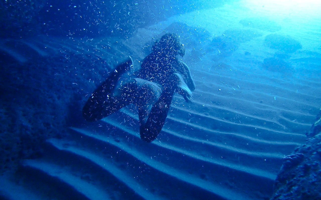 Diver exploring underwater Blue Cave, Koločep, Dubrovnik, Croatia.