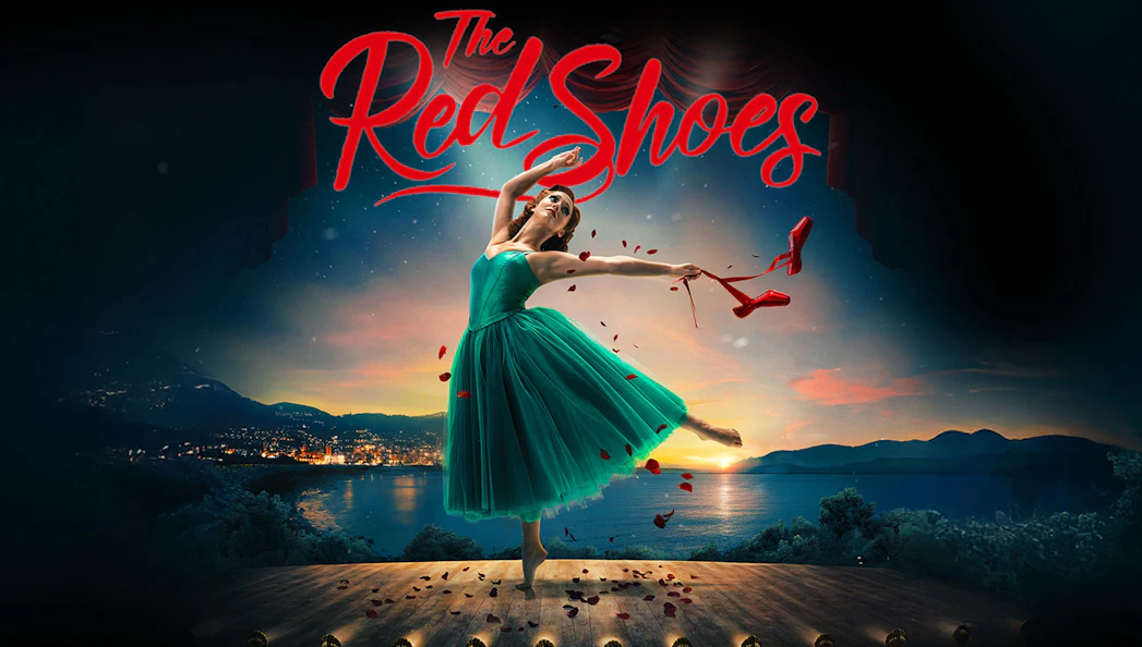 Ballet dancer on stage with red shoes in hand, backdrop of sunset over a lake, "The Red Shoes" text above.