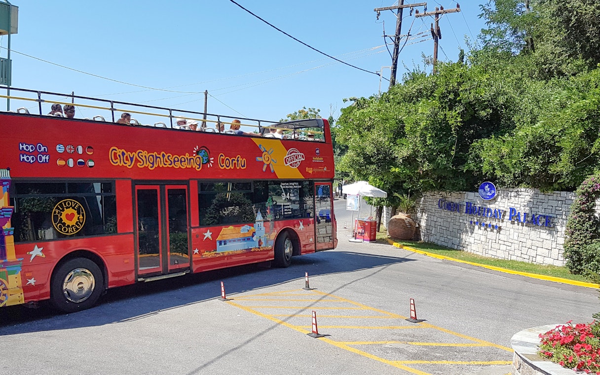 Red double-decker City Sightseeing bus near Corfu Holiday Palace entrance, Corfu.
