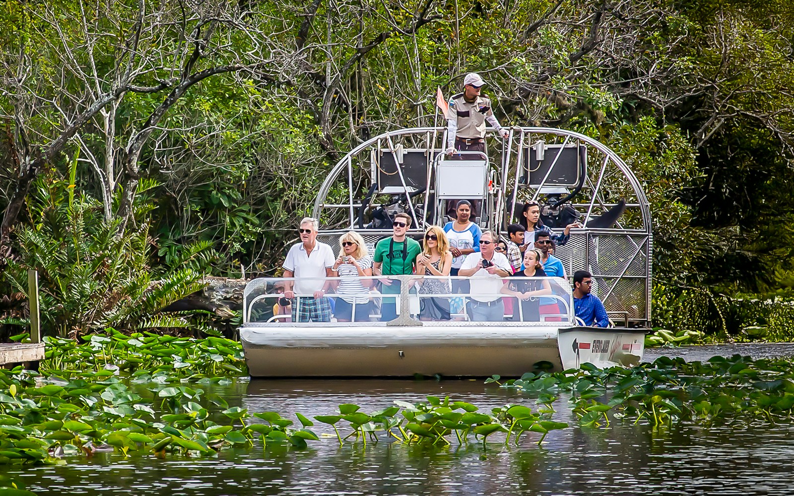 Airboat tour in Everglades Safari Park with group observing wildlife, Miami transfer included.