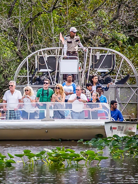 Airboat tour in Everglades Safari Park with group observing wildlife, Miami transfer included.