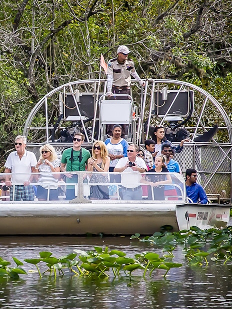 Airboat tour in Everglades Safari Park with group observing wildlife, Miami transfer included.