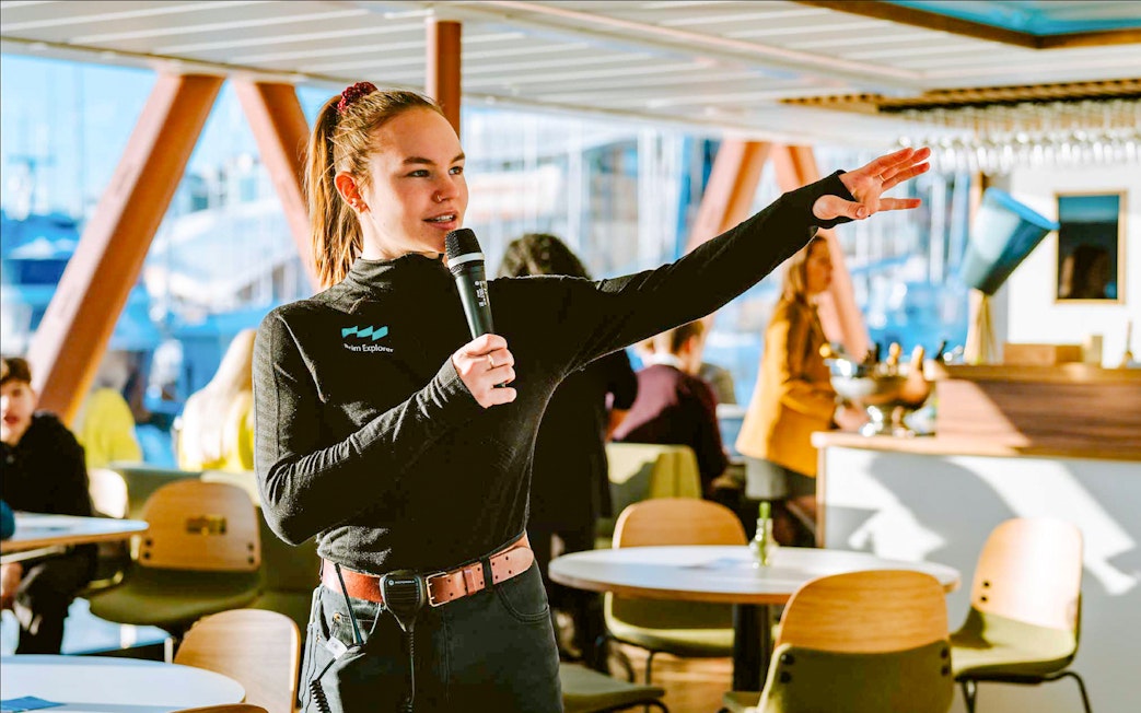 Guide speaking to passengers on a cruise ship.