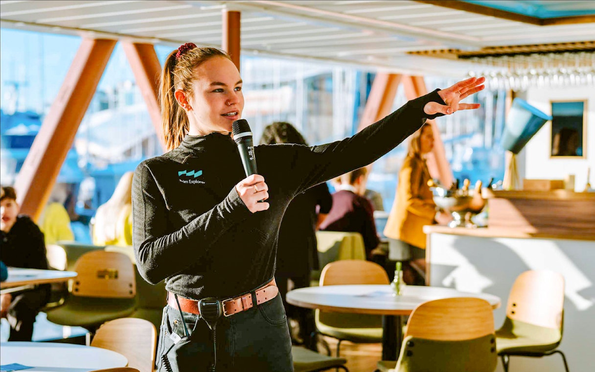 Guide speaking to passengers on a cruise ship.