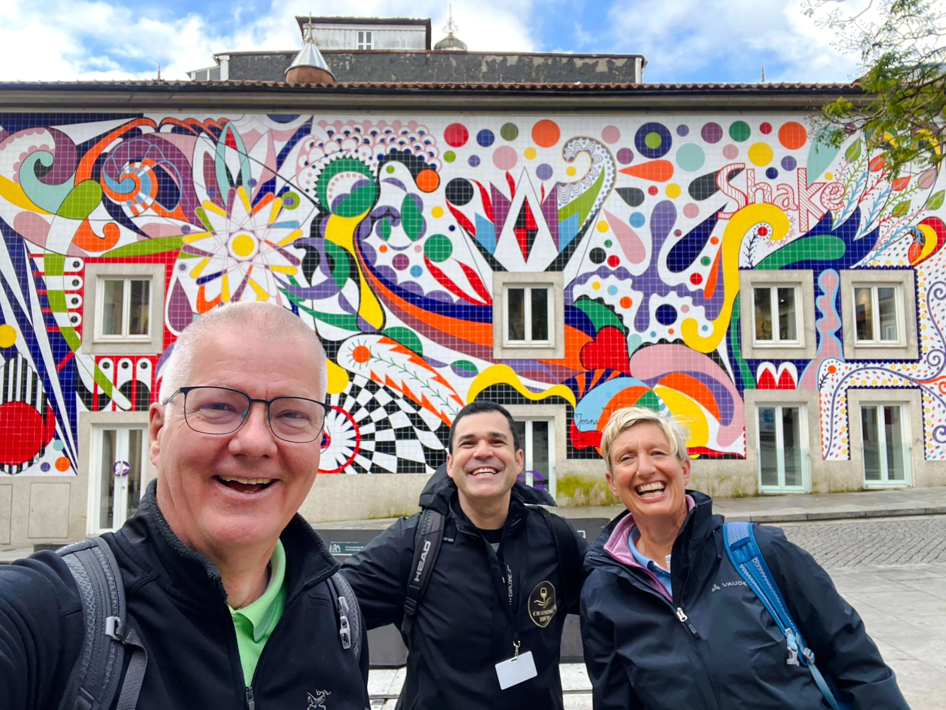 Group enjoying a walking tour in front of colorful mural in Porto.