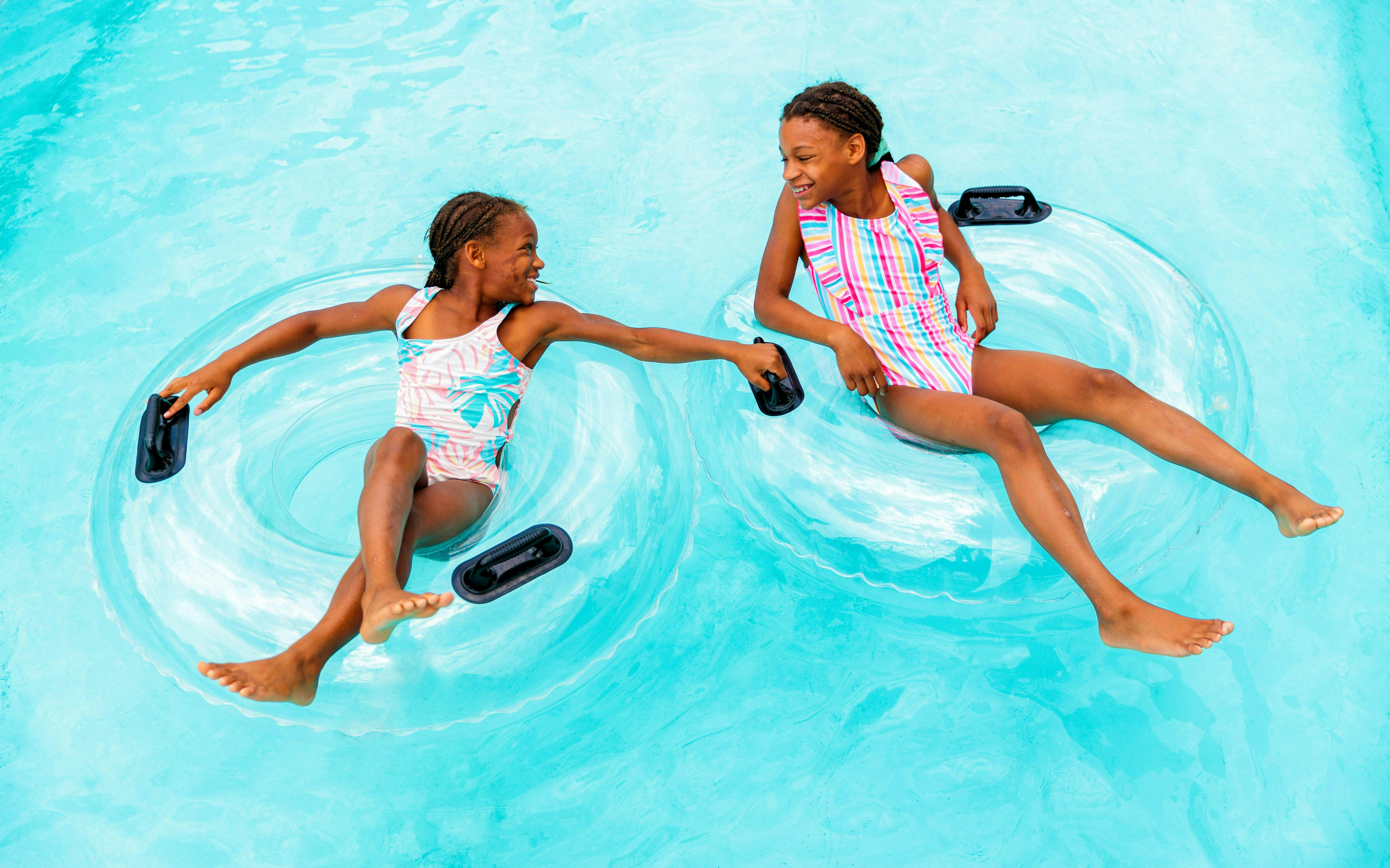 Children floating on inner tubes in Lazy River at Hurricane Harbor Arlington.
