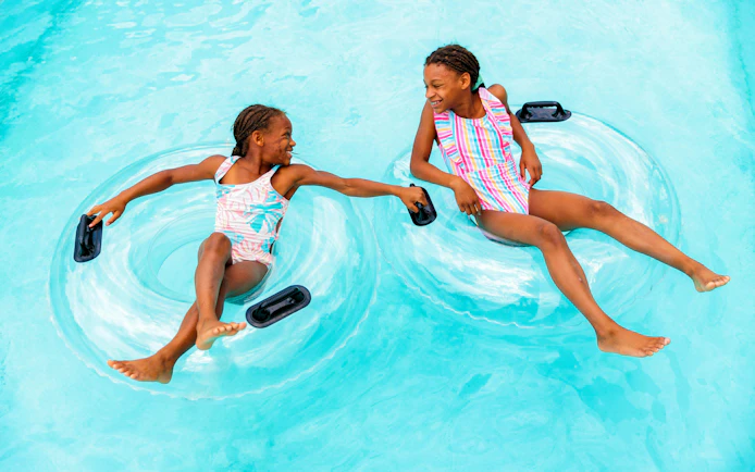 Children floating on inner tubes in Lazy River at Hurricane Harbor Arlington.