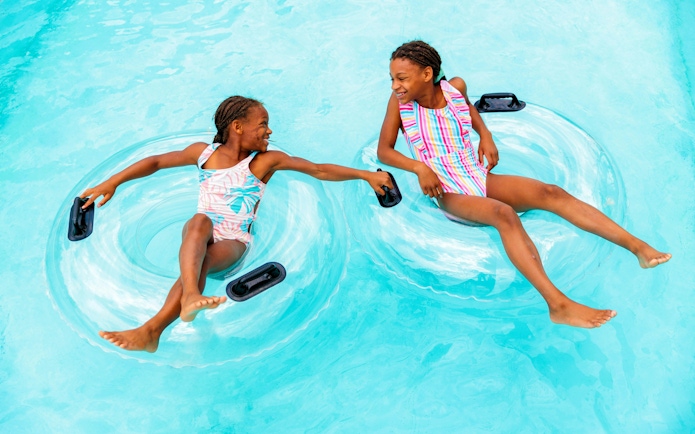 Children floating on inner tubes in Lazy River at Hurricane Harbor Arlington.