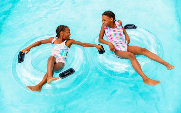 Children floating on inner tubes in Lazy River at Hurricane Harbor Arlington.