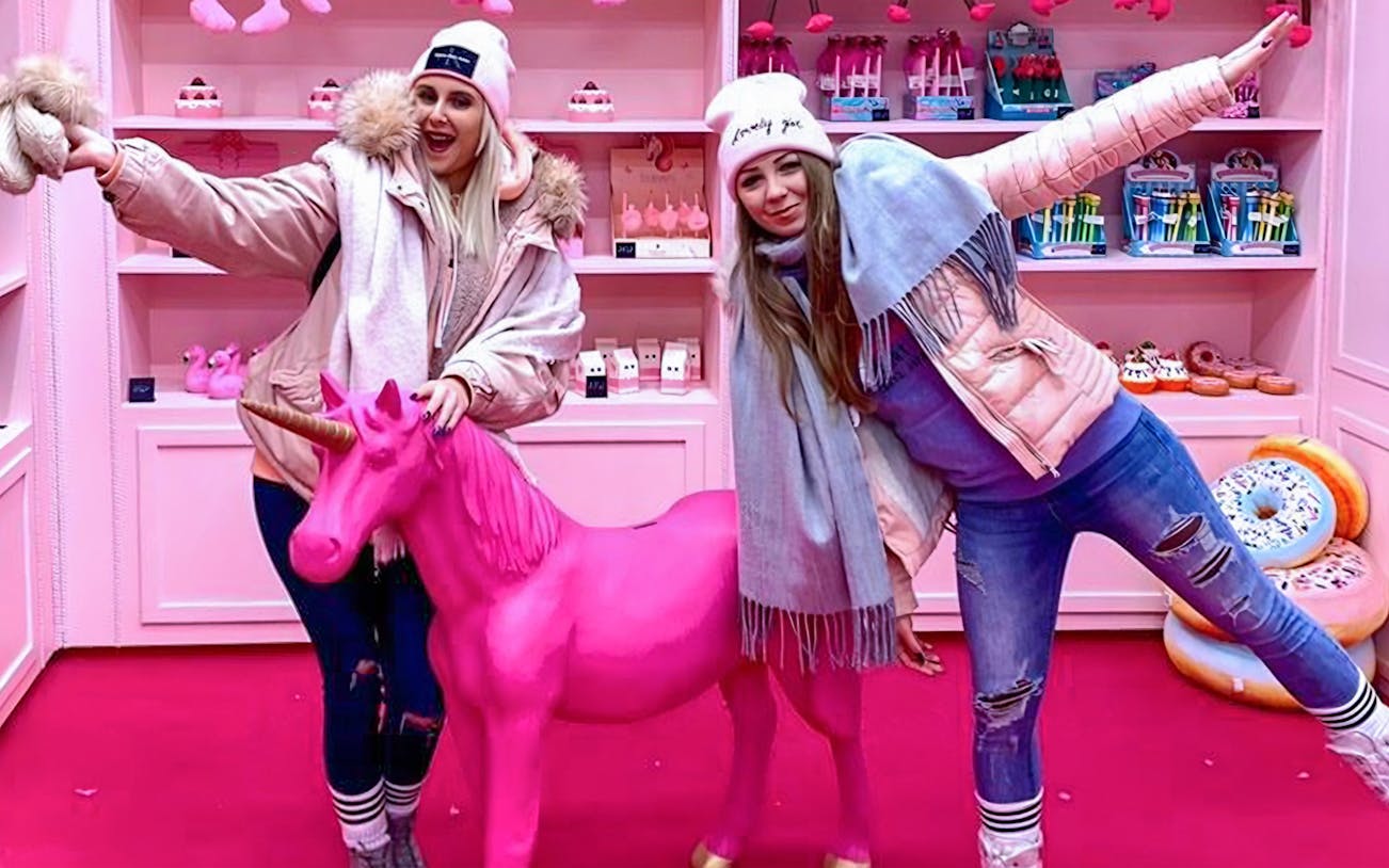 Visitors posing with a pink unicorn at Be Happy Museum, Zakopane.