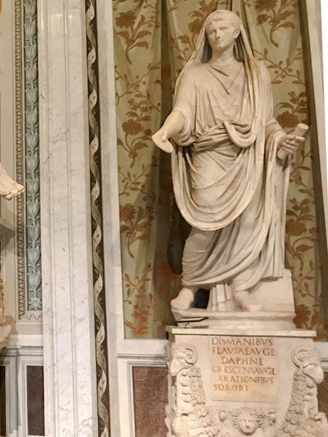 Marble statues in Borghese Gallery, Rome, depicting classical figures with intricate backgrounds.