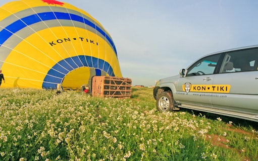 4x4 vehicle near hot air balloon setup in Montserrat field.
