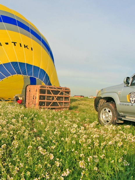 4x4 vehicle near hot air balloon setup in Montserrat field.