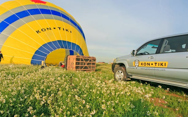 4x4 vehicle near hot air balloon setup in Montserrat field.