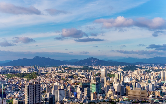 Aerial view of Seoul skyline with mountains in the background from N Tower.