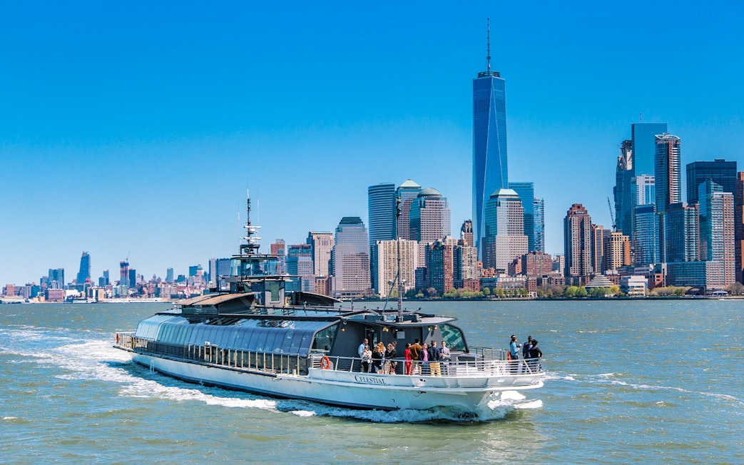 Cruise boat on Hudson River with New York City skyline in background.