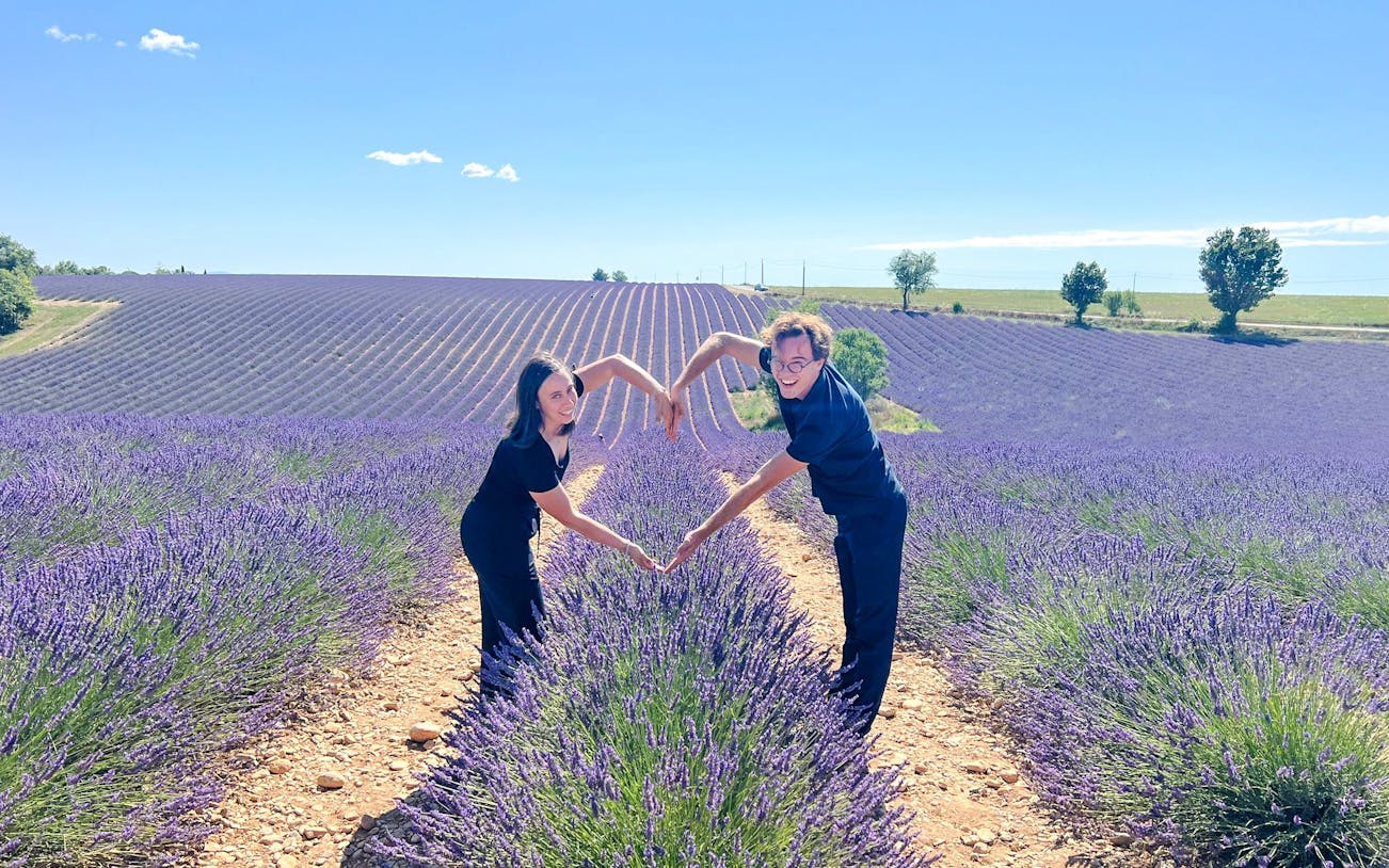 Couple forming heart shape in lavender fields, Valensole, Provence.