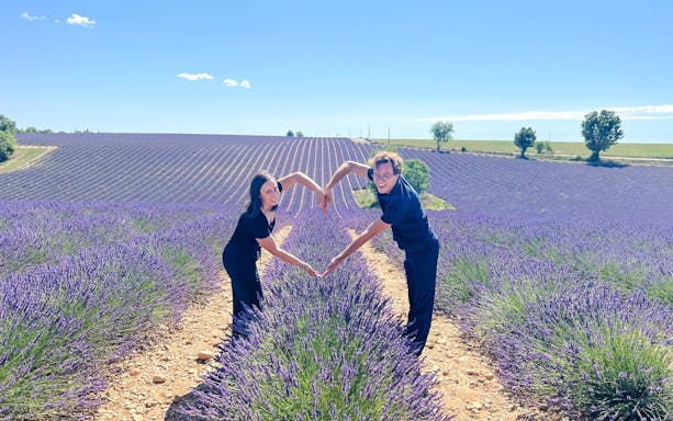 Couple forming heart shape in lavender fields, Valensole, Provence.