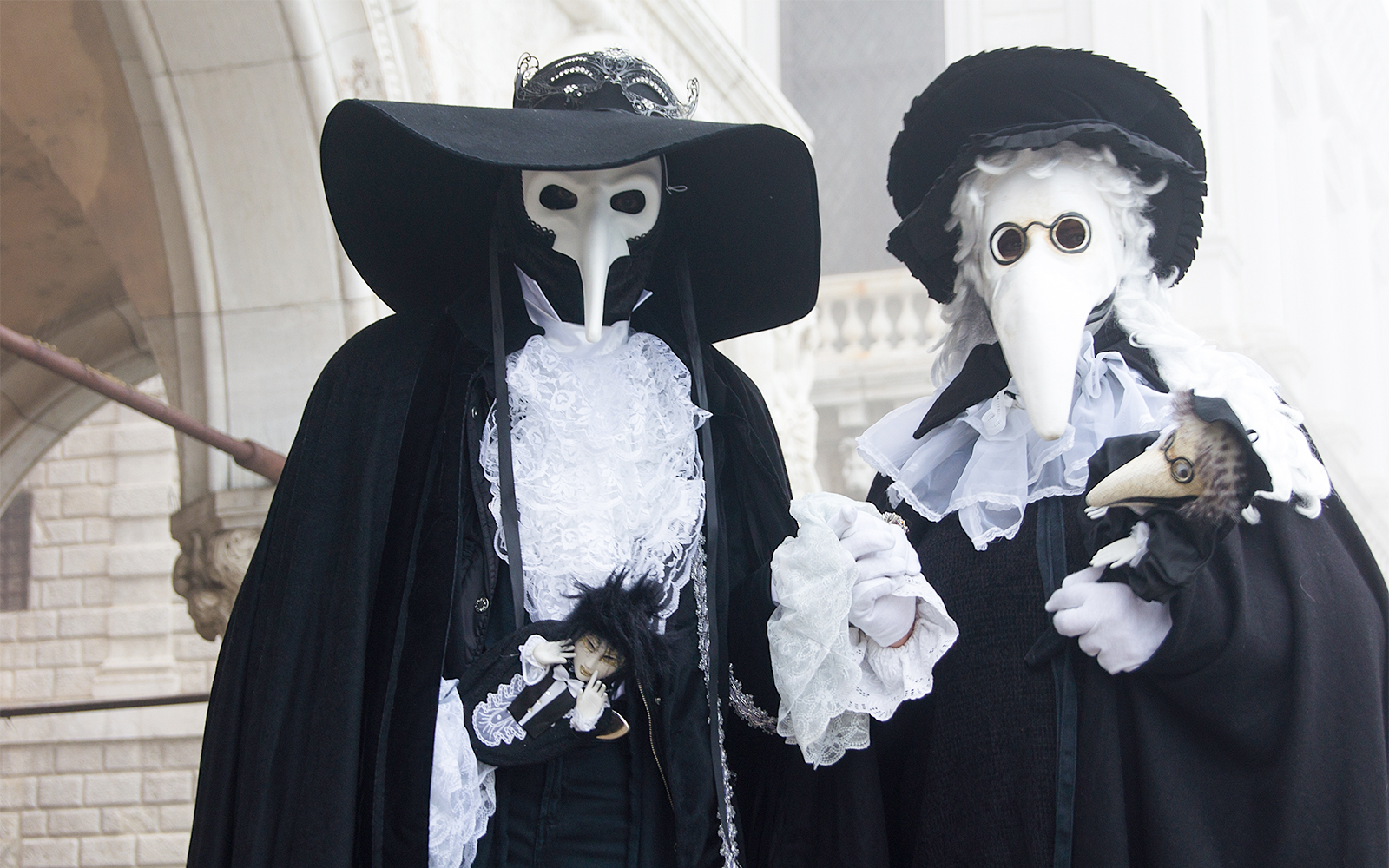 Venice Carnival participant in traditional plague doctor mask and costume.