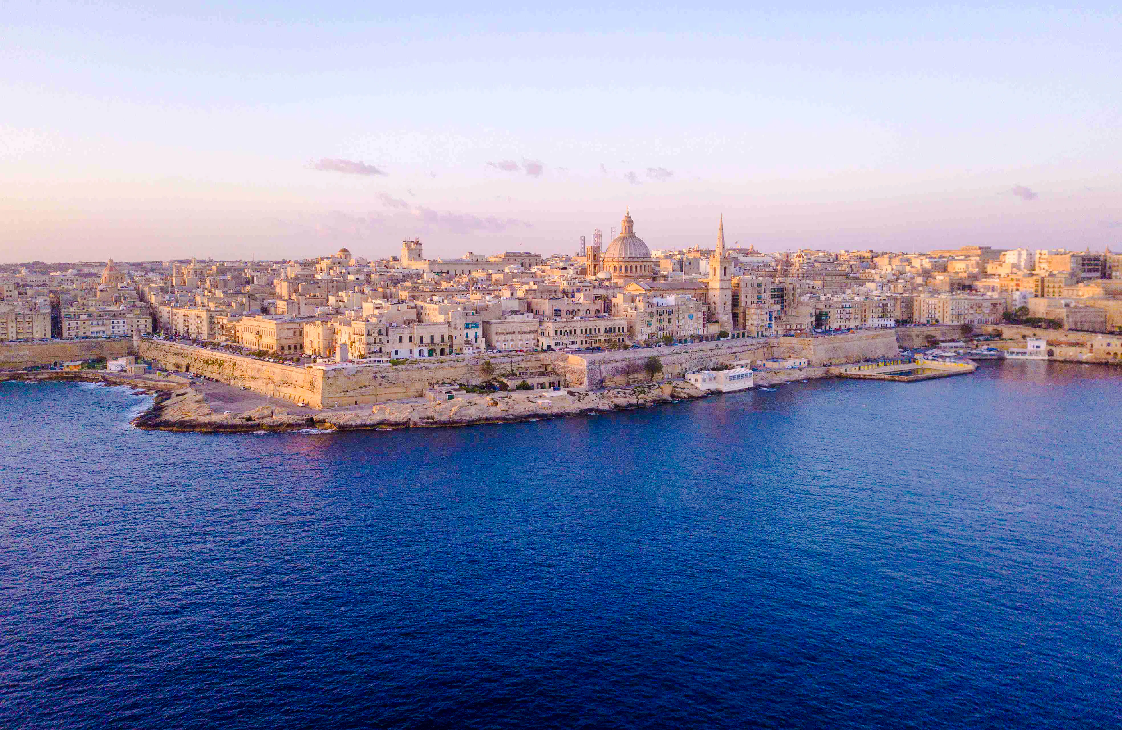 Aerial view of Valletta skyline from Sliema, Malta, featuring historic architecture along the coast.