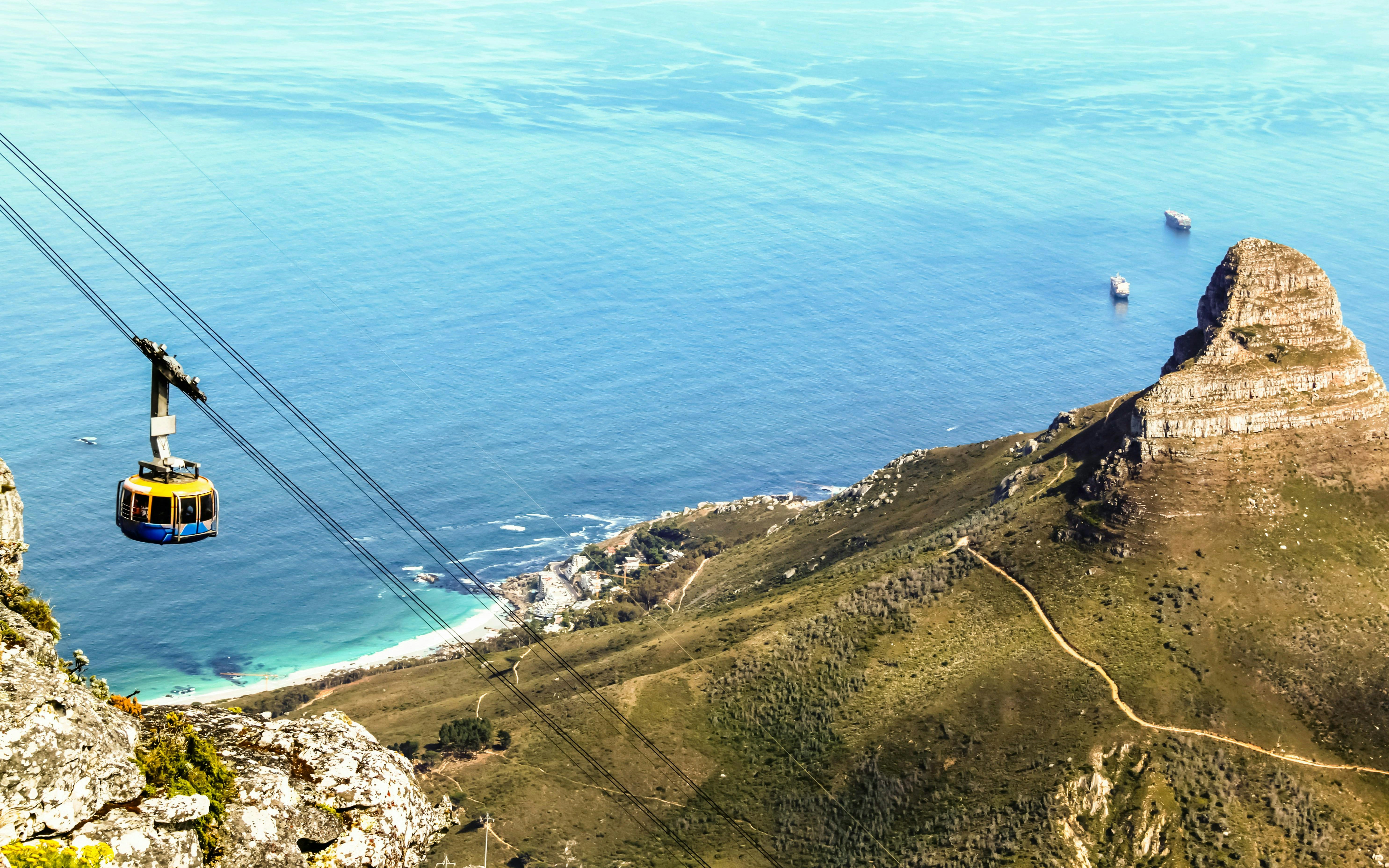 Cable car descending Table Mountain with ocean and Lion's Head view, Cape Town.