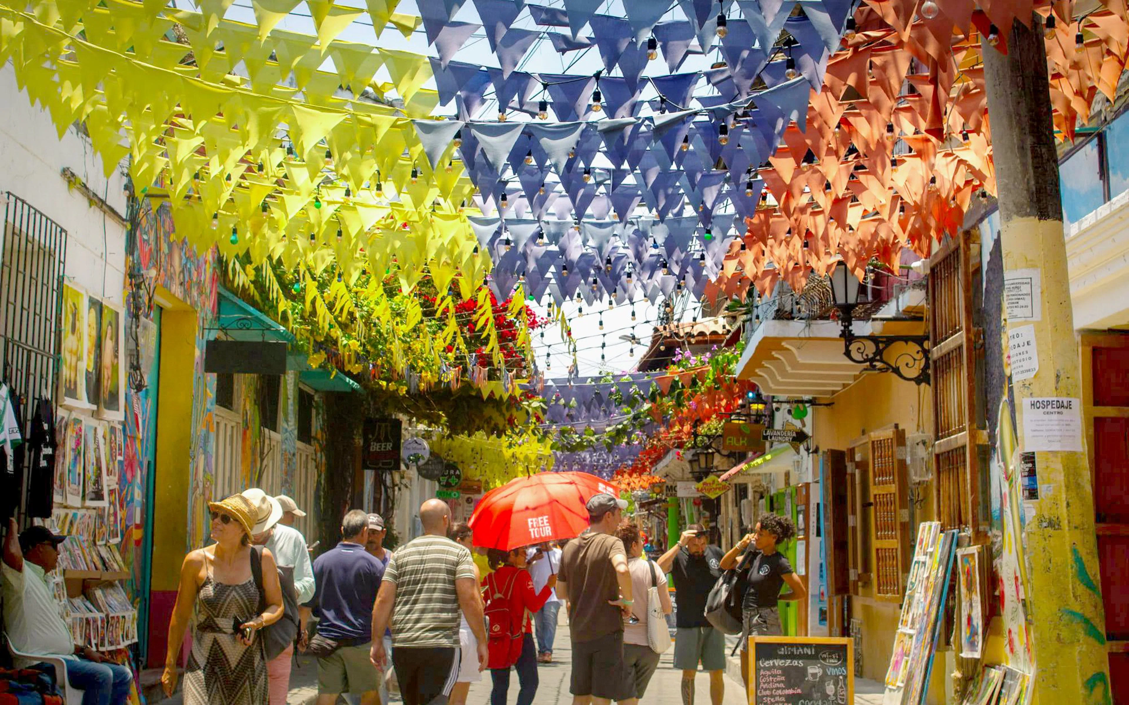 Colorful flags hanging over a busy street in Getsemaní, Cartagena.