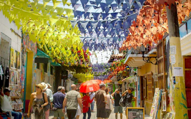 Colorful flags hanging over a busy street in Getsemaní, Cartagena.