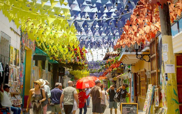 Colorful flags hanging over a busy street in Getsemaní, Cartagena.