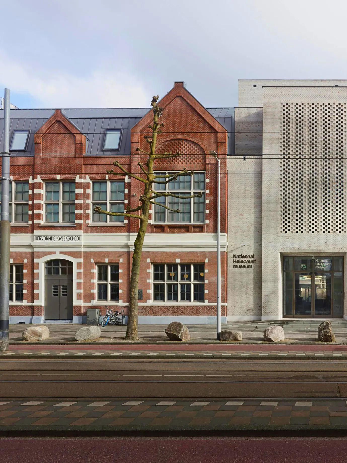 National Holocaust Museum entrance in Amsterdam with brick facade and modern design.