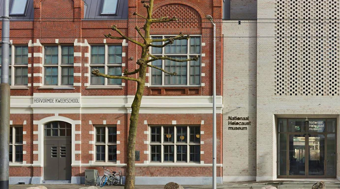 National Holocaust Museum entrance in Amsterdam with brick facade and modern design.