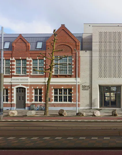 National Holocaust Museum entrance in Amsterdam with brick facade and modern design.
