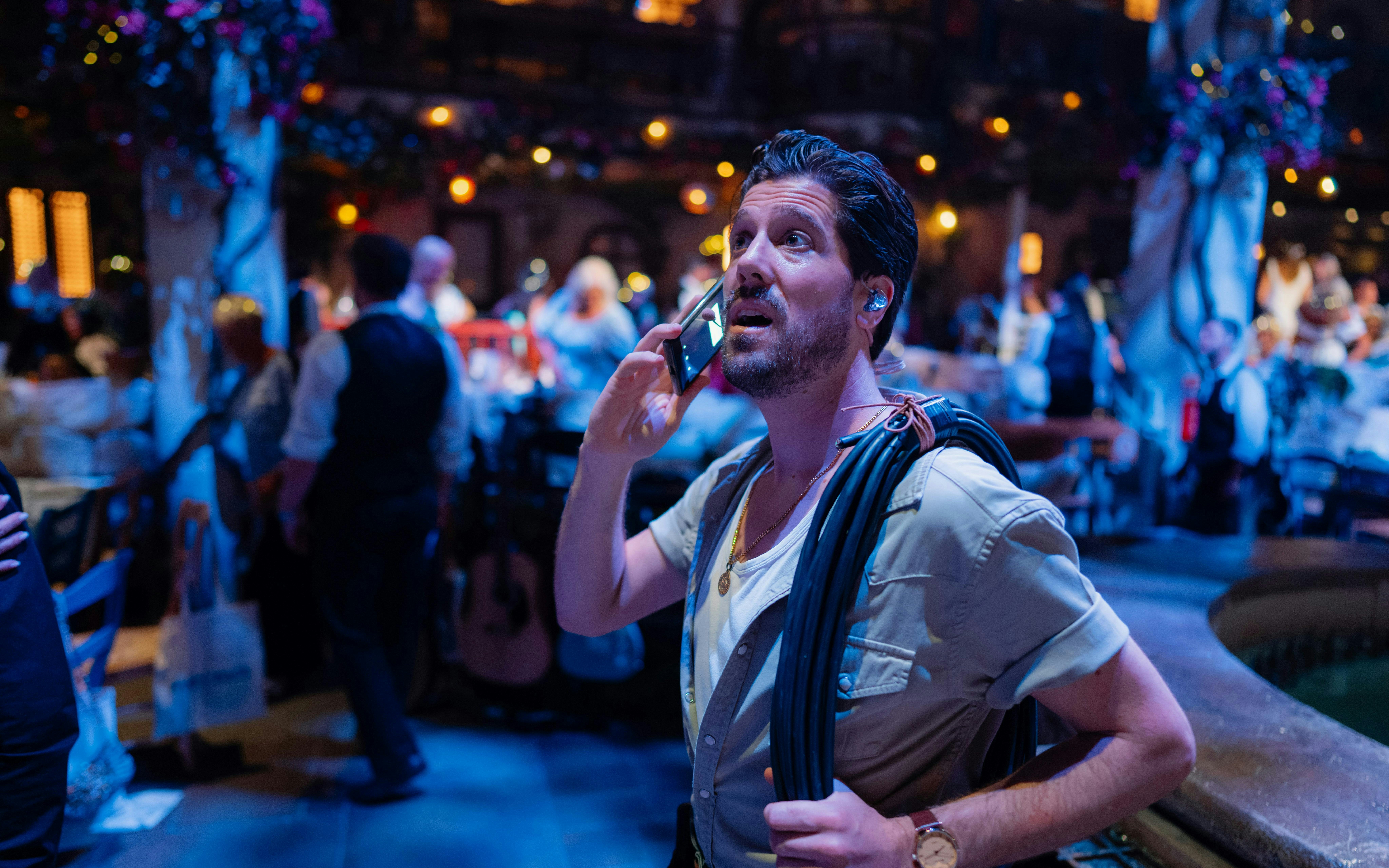Man with headset and phone during Mamma Mia! The Party performance setup.