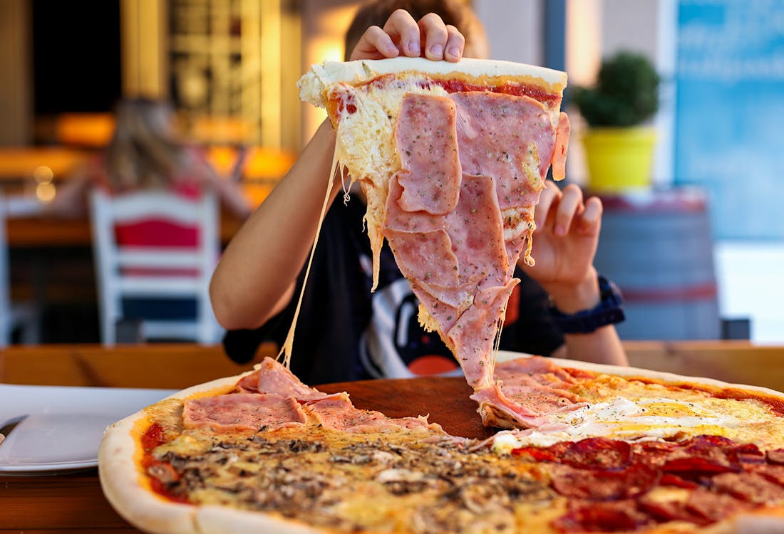 Child grabbing large pizza slice