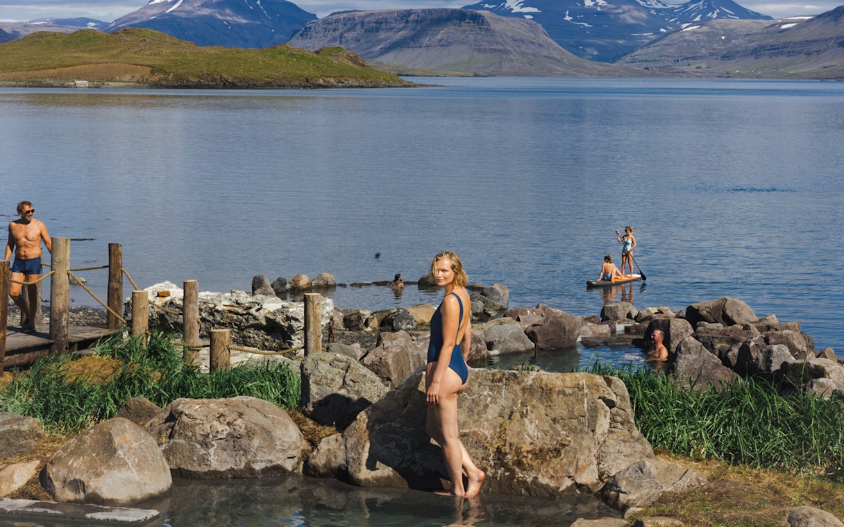 Hvammsvík Hot Spring visitors enjoying geothermal pools and paddleboarding near Reykjavík.