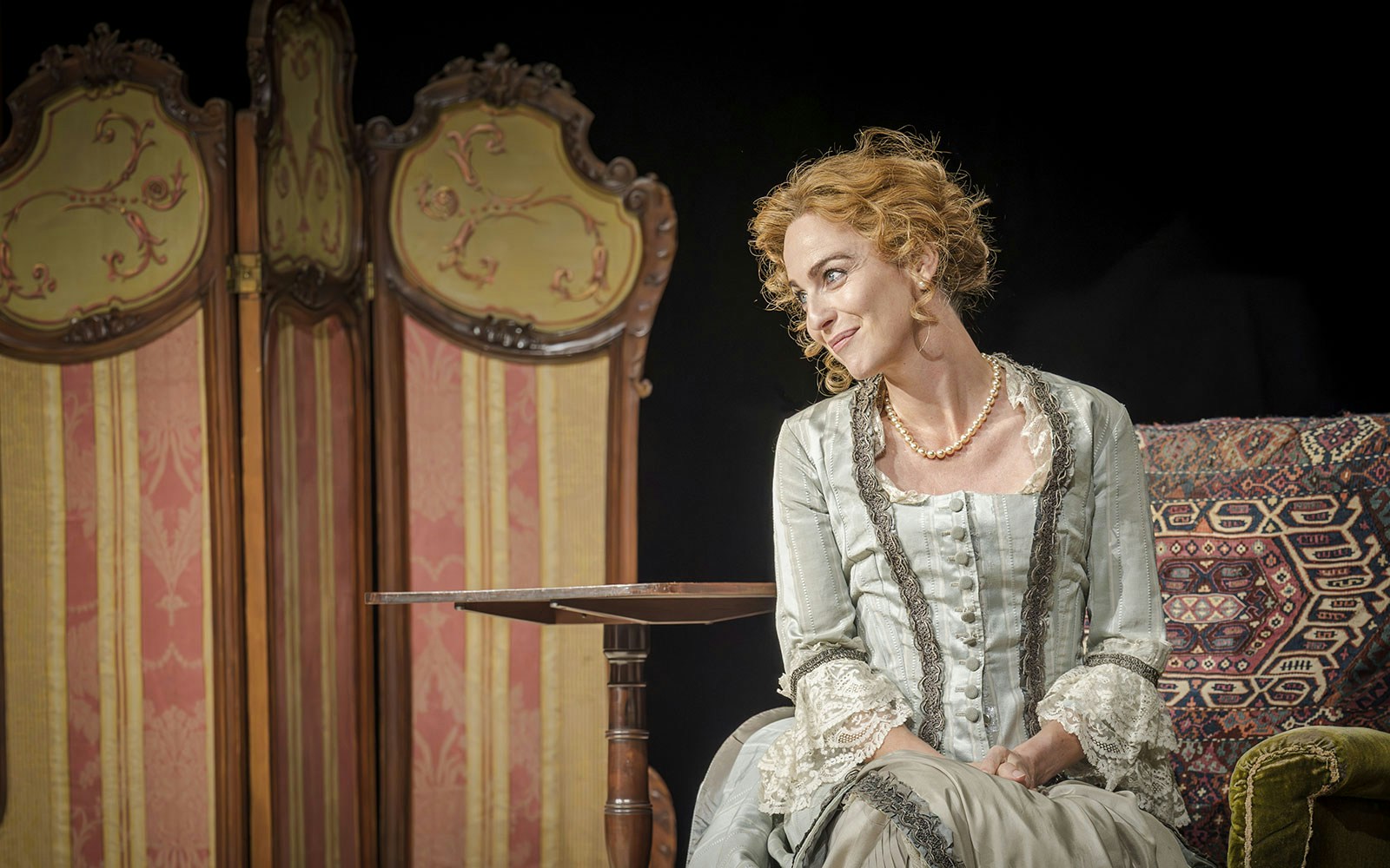 Performer in period costume on stage during Grace Pervades West End show.