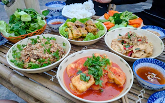 Vietnamese dishes on a bamboo table during Tam Coc Pedal & Paddle tour, Ninh Binh.