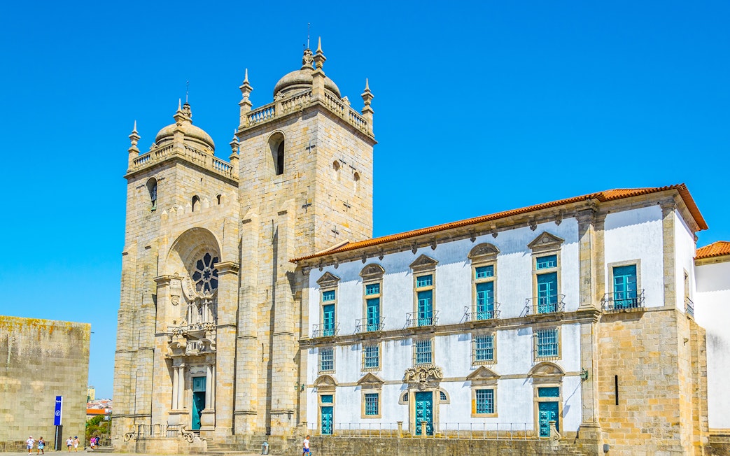 Porto Cathedral's facade with twin towers under a clear blue sky in Porto, Portugal.