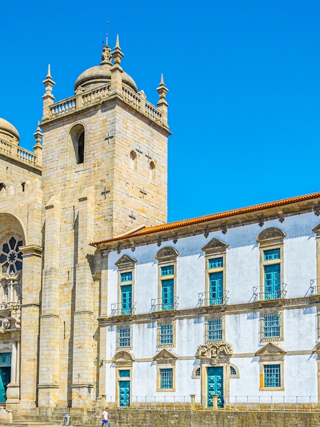 Porto Cathedral's facade with twin towers under a clear blue sky in Porto, Portugal.