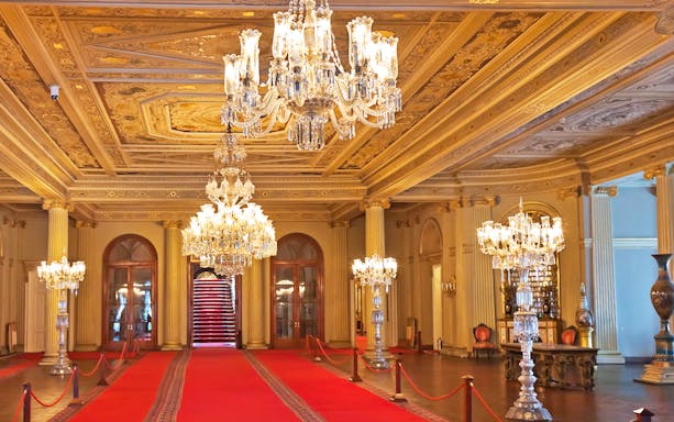 Dolmabahce Palace interior with ornate chandeliers and red carpet.