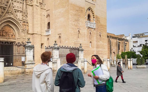 Tour guide leading a group near Seville Cathedral on a walking tour.