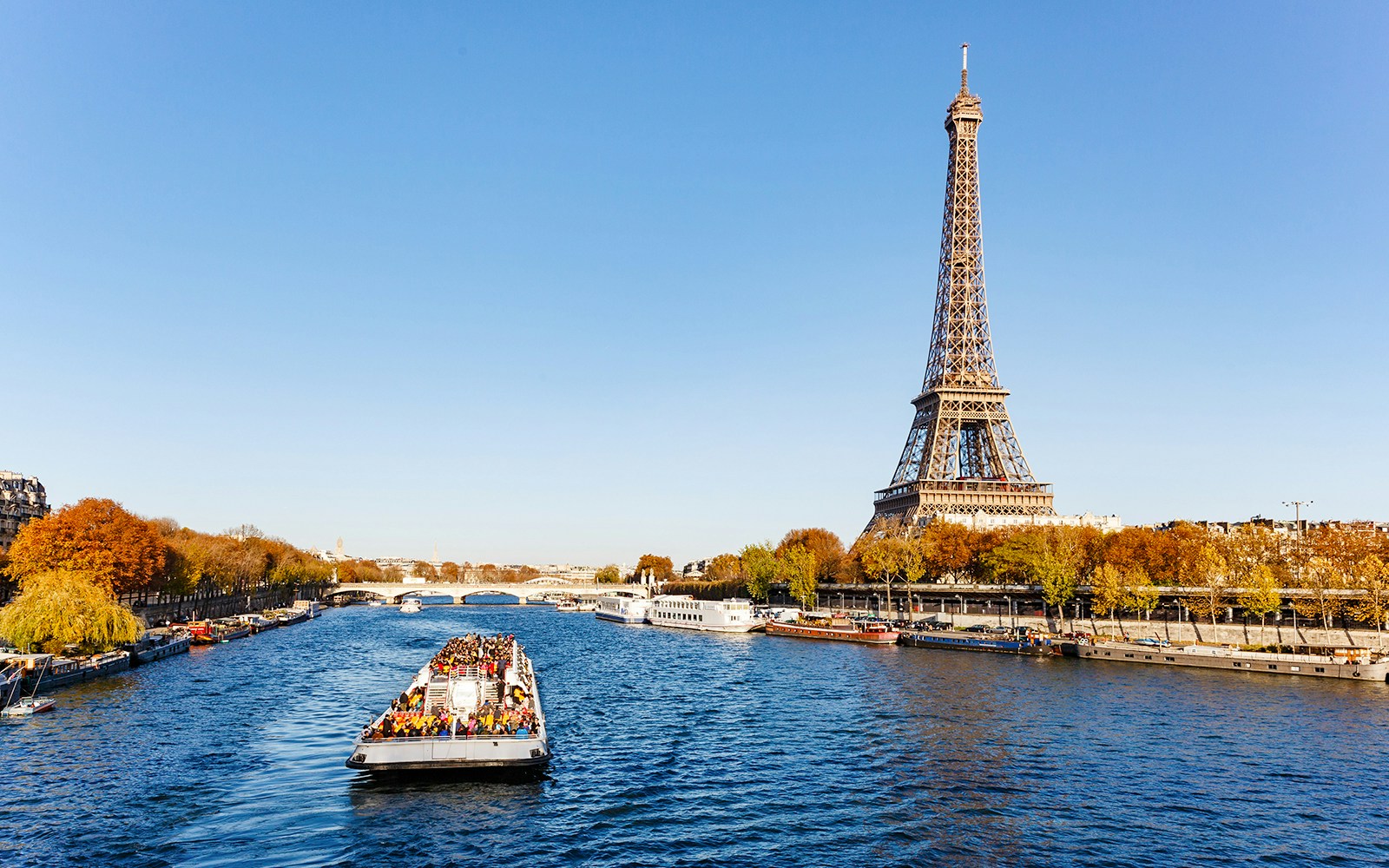 Seine River cruise boat with Eiffel Tower in background, Paris.