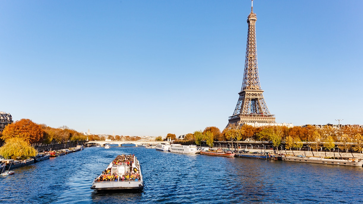 Seine River cruise boat with Eiffel Tower in background, Paris.