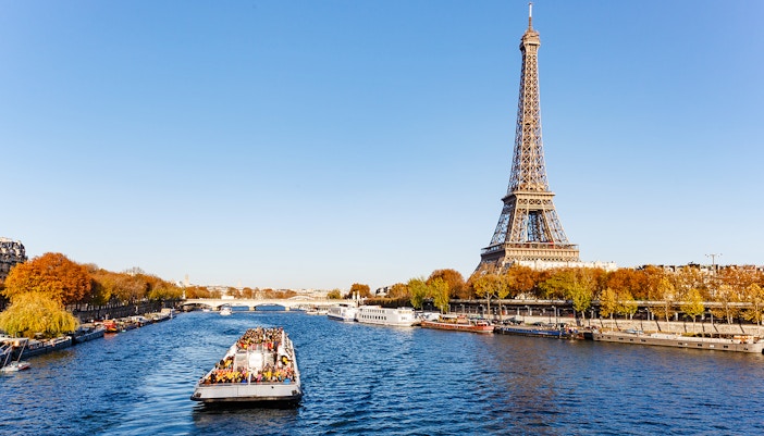 Seine River cruise boat with Eiffel Tower in background, Paris.
